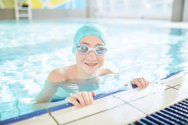 スイム キャップ ゴーグルは 水泳プールの純粋な水に立って若いスイマー — ストック写真