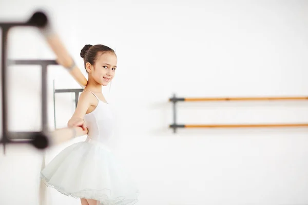 穿着芭蕾舞裙的快乐女孩在课堂上练习微笑看镜头 — 图库照片