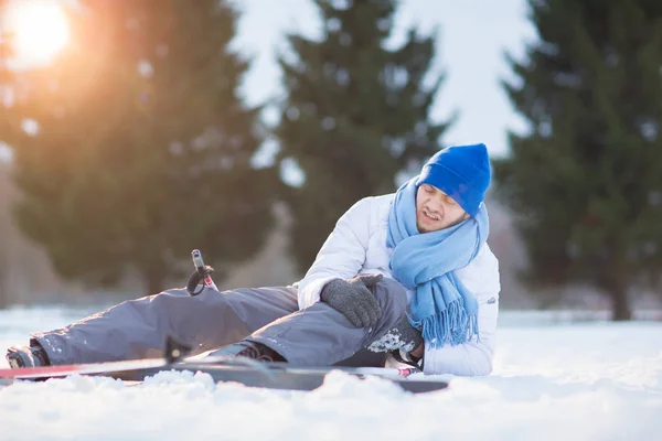 Молодий Спортсмен Потирає Коліно Після Аварії Снігу Під Час Тренувань — стокове фото
