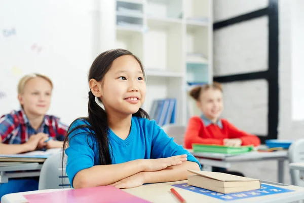 Little Asian Schoolgirl Sitting Desk Her Classmates Background — Stock Photo, Image