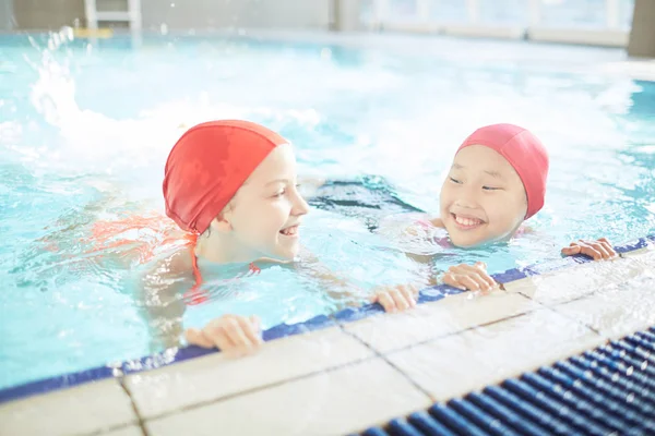 Twee Vriendelijke Schoolmeisjes Plezier Tijdens Het Beoefenen Van Zwemmen Zwembad — Stockfoto