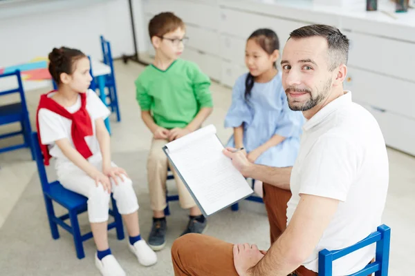 Glad Lärare Med Dokument Kontrollera Kunskap Hans Elever Lektionen — Stockfoto