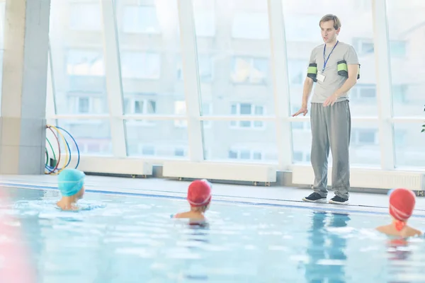 Junglehrer Steht Rand Des Schwimmbades Und Gibt Seinen Schülern Anweisungen — Stockfoto