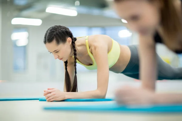 Mujeres Jóvenes Ropa Deportiva Haciendo Tablones Suelo Mientras Entrenan Gimnasio —  Fotos de Stock