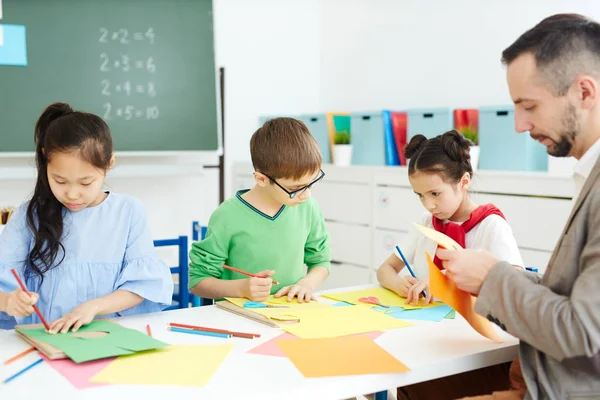 Три Школьника Учитель Делают Творческие Игрушки Цветной Бумаги Уроке — стоковое фото