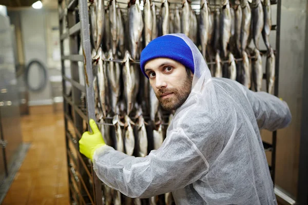 Giovane Uomo Tuta Guanti Spingendo Carrello Con Pesce Appeso Guardando — Foto Stock