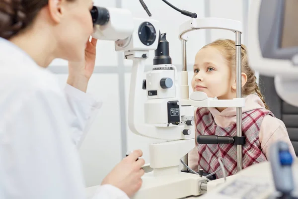 Jonge Behandelaar Controleren Gezichtsvermogen Van Meisje Professionele Apparatuur Stockfoto