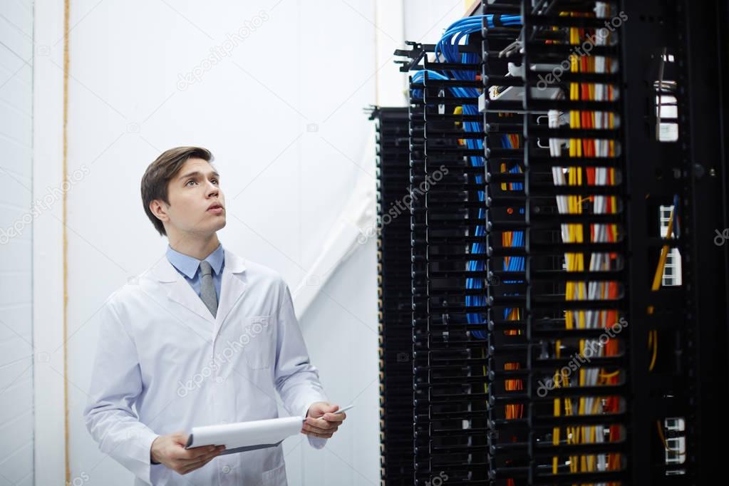 Engineer of data center looking at new bitcoin hardware while working in storage room