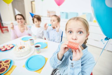 Islık ve balon anaokulunda doğum günü partisi kameraya bakarak ile kız