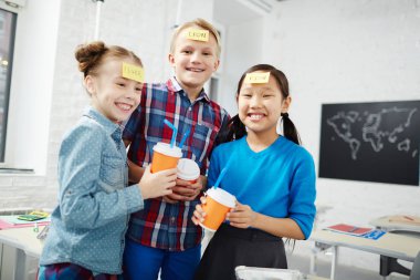 Gülen sınıf arkadaşlarıyla öğle yemeği sırasında isim oyunu oynarken içecekler okulda zorla