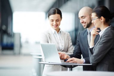 Takım Havaalanı laptop önünde salonda oturan ve online veri tartışırken iş ortakları