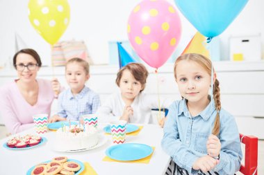 Doğum günü partisinde şenlikli tabloya göre pembe balon, arkadaşları ve öğretmen ile şirin çocuk toplandı
