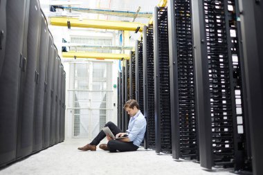 Öğrenmek ve teknik sorunu çözmek için genç Yöneticisi'nden BT desteği cryptofarm katta oturan ve çalışan dizüstü bilgisayar ile