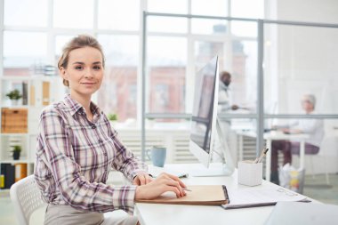 Ofis onun işyerinde başına oturmuş, Not Defteri'nde yapma ve kameraya bakarak genç iş kadını