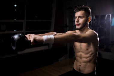 Adam gergin kollu spor salonunda eğitim sırasında kettlebell kaldırma