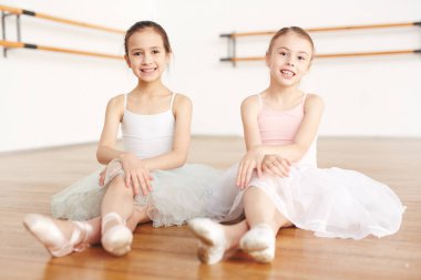 Sınıf katta oturan sevimli küçük bale öğrenenler beyaz giyinmiş