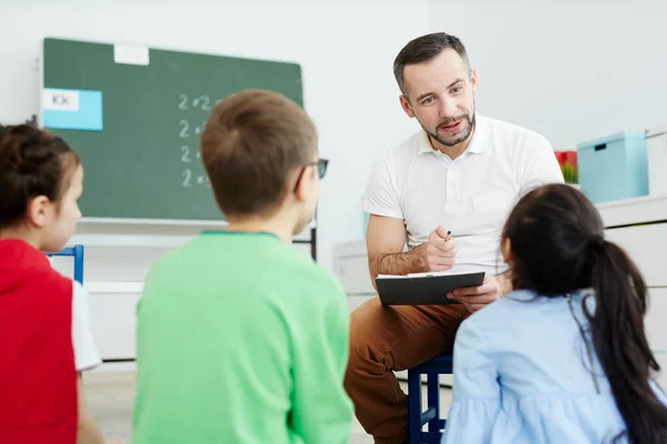 Zeitgenössischer Lehrer Zeigt Auf Eines Der Kinder Während Ihren Antworten — Stockfoto