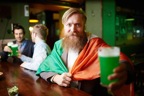 有胡子的人与国家爱尔兰国旗和玻璃啤酒看在酒吧的相机 — 图库照片