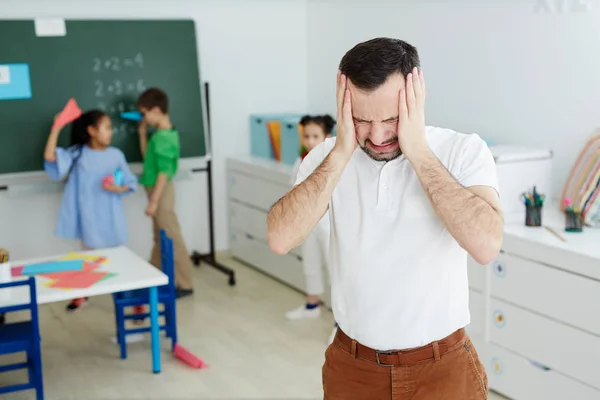 Naštvaný Učitel Dotýká Hlavu Během Přestávky Mezi Lekce Při Skupina — Stock fotografie