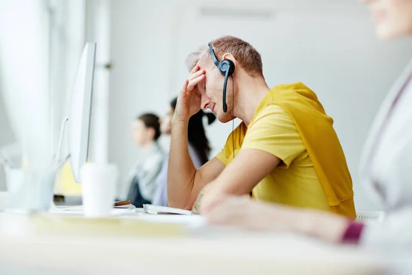 疲劳或压力呼叫中心经理与耳机坐在工作场所和听取客户投诉之一 — 图库照片