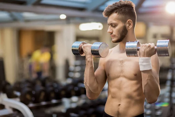 Ung Muskulös Man Tränar Med Hantlar Medan Tränar Gymmet — Stockfoto