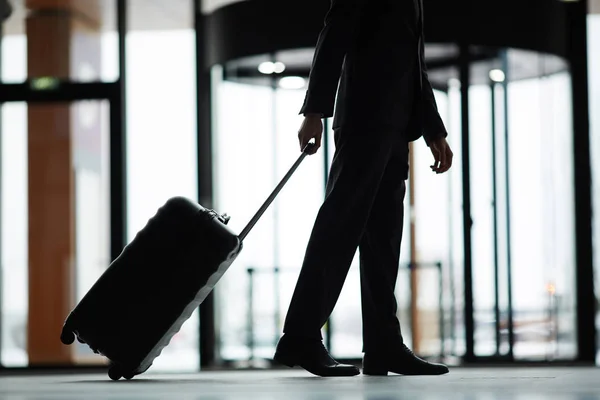 スーツケース近代的な空港を移動とビジネス旅行者の Lowsection のシルエット — ストック写真