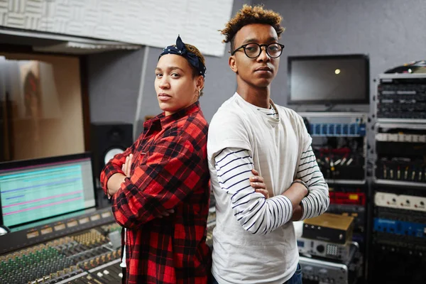 Two cool sound studio operators in hipster style clothes crossing their arms on chest