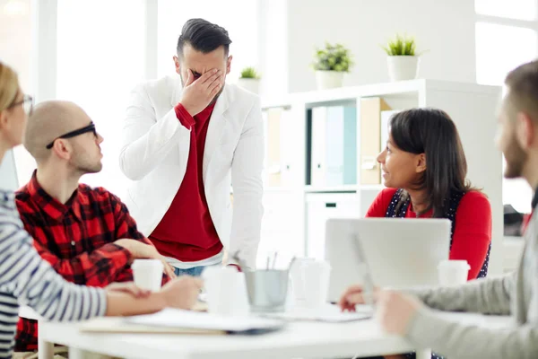 Jovem Empresário Expressando Confusão Frente Seus Colegas Durante Reunião Trabalho — Fotografia de Stock