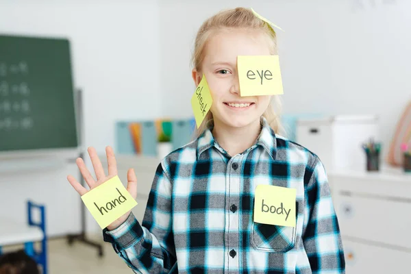 Glückliches Schulmädchen Mit Klebrigen Zetteln Mit Englischen Namen Von Körperteilen — Stockfoto