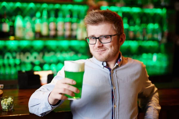 Όμορφος Νεαρός Άνδρας Γυαλιά Που Κρατά Ποτήρι Μπύρα Αφρίζοντας Κλίνοντας — Φωτογραφία Αρχείου