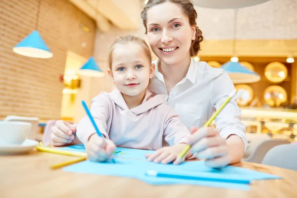 年轻的现代女性和她的小女儿在闲暇时画蜡笔画 — 图库照片