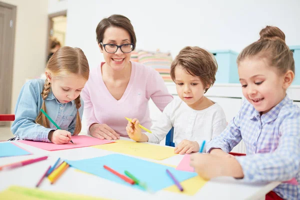 Felice Insegnante Tre Bambini Seduti Tavolo Disegnare Lezione Nella Scuola — Foto Stock