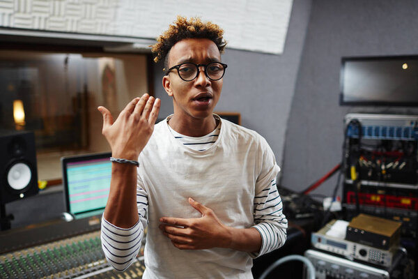 Contemporary young deejay of sound studio explaining something to his client