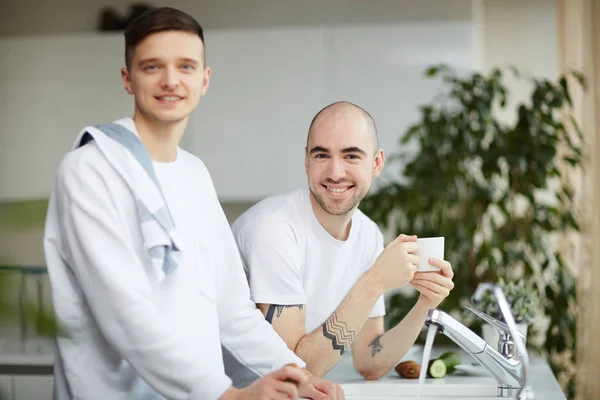 Szczęśliwa Para Gejów Patrząc Kamery Pobliżu Streaming Wody Kuchni — Zdjęcie stockowe