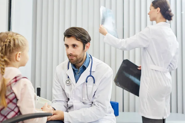 Giovane Medico Che Ascolta Poco Paziente Mentre Suo Assistente Background — Foto Stock