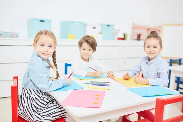 かわいい Fritndly 幼稚園のテーブルによって収集された普段着のまま描画する子供たち — ストック写真