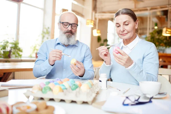 Casal Sênior Sentado Mesa Pintando Ovos Para Festa Páscoa Com — Fotografia de Stock