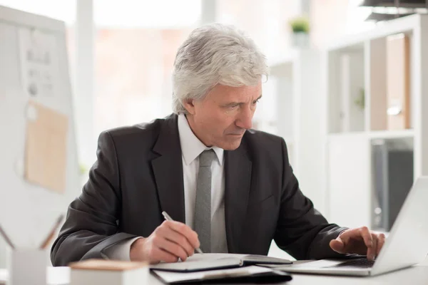 Seriöser Chef Anzug Sitzt Mit Laptop Vor Dem Arbeitsplatz Und — Stockfoto