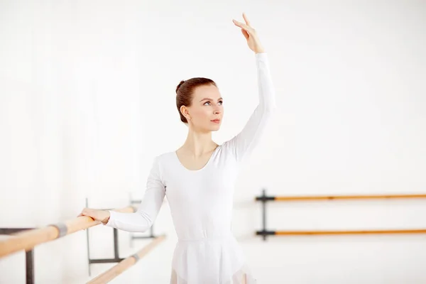 Молодая Балерина Белом Костюме Стоит Деревянных Баров Поднятой Рукой — стоковое фото