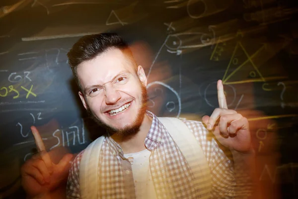 Ecstatic Guy Keeping His Forefingers Raised While Standing Blackboard — Stock Photo, Image