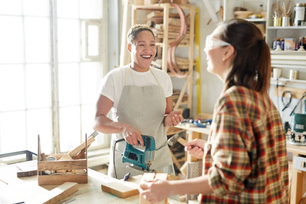 Timmerman Lachen Met Powertool Kijken Naar Haar Collega Tijdens Gesprek — Stockfoto