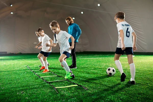 Jeunes Enfants Uniforme Faisant Exercice Pendant Entraînement Football Sur Pelouse — Photo