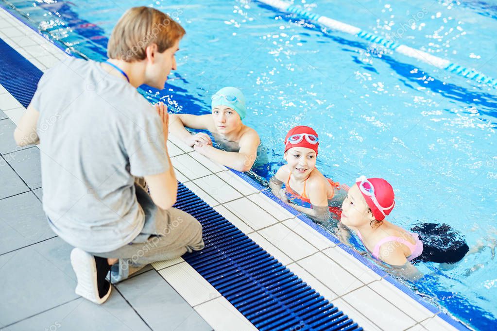 Swim trainer explaining his learners in swimming-pool what to do next