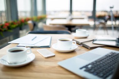 Fincan sade kahve, becerikli alet ve hiç kimse ile kafede masada finansal belgeler