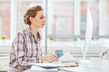 Ciddi genç Yöneticisi veya web tasarımcısı ofiste çalışırken bilgisayar monitörü arıyorsunuz