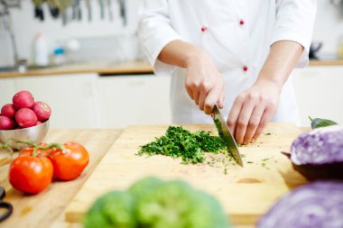 Vejetaryen yiyecekler yemek sırasında Şef kesme yeşillik mutfakta ahşap tahta üzerinde