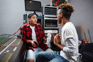 İki profesyonel ses kayıt operatörleri ses stüdyosunda konuşmayı