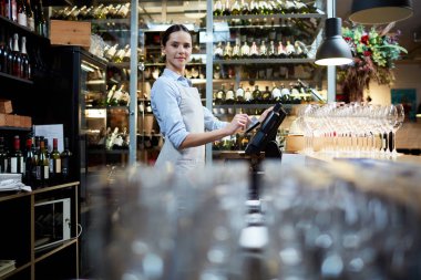 Genç personelin bilgisayar tarafından ayakta ve en son siparişleri ve ödemeler hakkında veri girerek Restoran