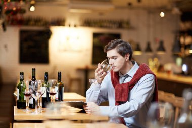 Birkaç türlü iş yerinde kırmızı şarap tatma bardağı ile genç sommelier