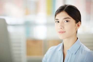 Ofiste çalışırken kameraya bakıyor ışık mavi gömlekli genç ve güzel uzmanı